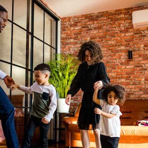 A family of four playing in the living room