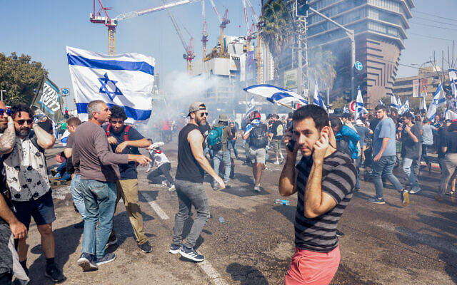 Demonstrators block a road and clash with police who deploy tear gas as they protest against the government's planned judicial overhaul, in Tel Aviv, March 1, 2023. Photo: Erik Marmor/Flash90