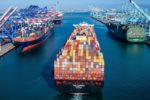 AERIAL VIEW OF LARGE CONTAINER SHIPS IN A SHIPPING CHANNEL AT A PORT