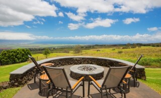 Luxury backyard fire pit surrounded by outdoor seating area and panoramic views