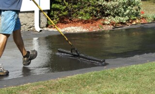 sealing an asphalt driveway with a brush