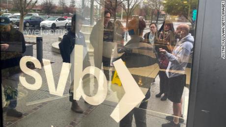 People line up outside of the shuttered Silicon Valley Bank (SVB) headquarters on March 10, 2023 in Santa Clara, California. Silicon Valley Bank was shut down on Friday morning by California regulators and was put in control of the U.S. Federal Deposit Insurance Corporation. Prior to being shut down by regulators, shares of SVB were halted Friday morning after falling more than 60% in premarket trading following a 60% declined on Thursday when the bank sold off a portfolio of US Treasuries and $1.75 billion in shares to cover  declining customer deposits. 