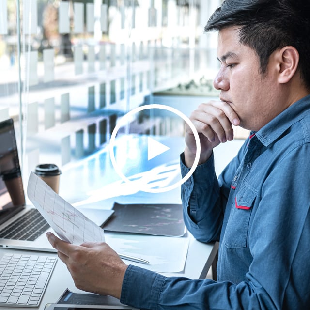 Image of male employee looking at a piece of paper