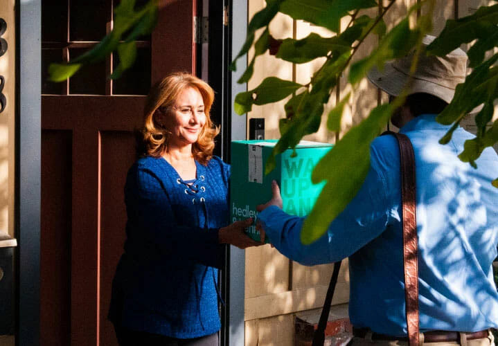 woman accepting hedley and bennett package from delivery person