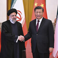 Visiting Iranian President Ebrahim Raisi, left, shakes hands with Chinese President Xi Jinping before their meeting at the Great Hall of the People in Beijing, February 14, 2023. (Yan Yan/Xinhua via AP)