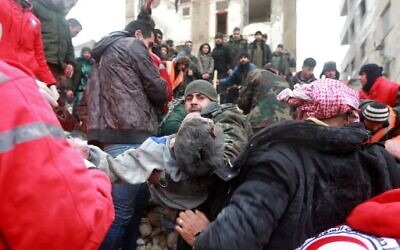 Syrian rescue teams carry a casualty picked up from the rubble after an earthquake in the government-controlled central Syrian city of Hama on February 6, 2023. (LOUAI BESHARA / AFP)