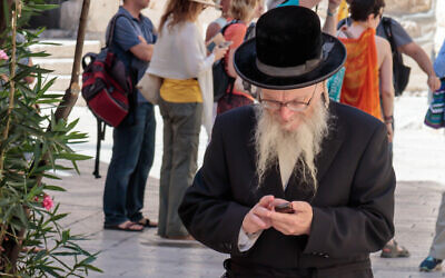 Illustrative: A Haredi man looks at his mobile phone in Jerusalem, Israel (svarshik/iStock by Getty Images)