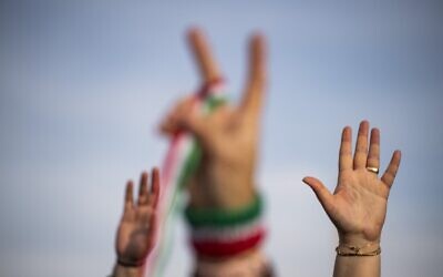 People raise their hands during a demonstration to denounce the Iranian government at the Lincoln Memorial in Washington, DC, on February 11, 2023. (Roberto Schmidt / AFP)