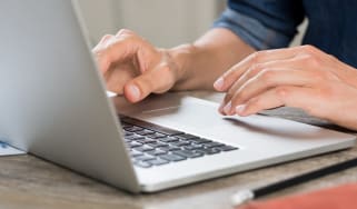 Close-up of a small business employee using a laptop on a table