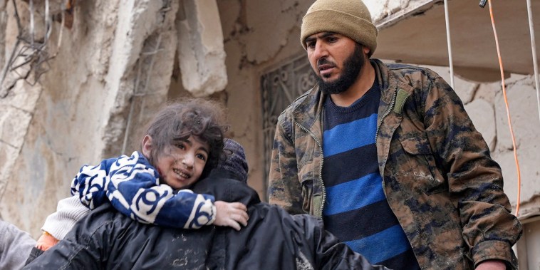 Residents retrieve a child from the rubble in Jandaris in a rebel-held area of Syria's Aleppo province.