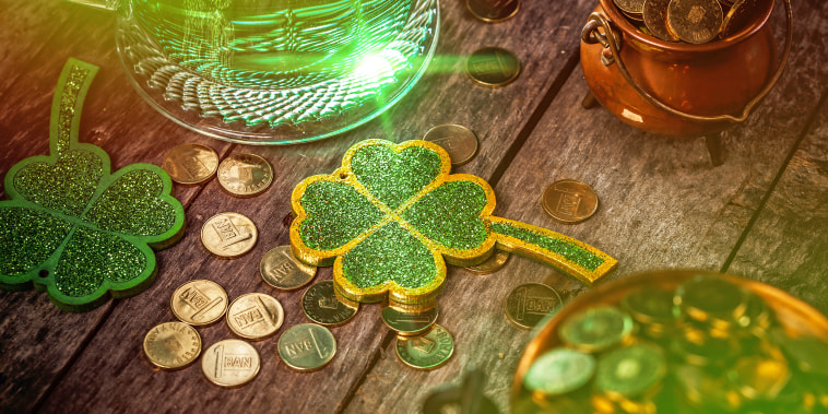 Green beer, shamrock and coins on wooden table for St. Patrick's day.