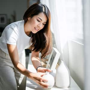 Woman tidying up decoration in living room