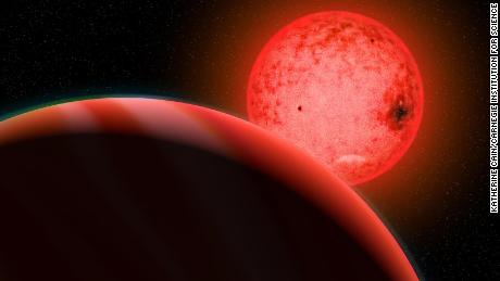 Artist&#39;s conception of a large gas giant planet orbiting a small red dwarf star called TOI-5205. 