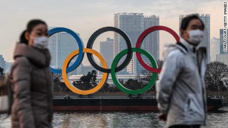 TOKYO, JAPAN - JANUARY 22: People wearing face masks walk past the Olympic Rings on January 22, 2021 in Tokyo, Japan. With just six months to go until the start of the Games, it has been reported that the Japanese authorities have privately concluded that the Olympics could not proceed due to the ongoing Covid-19 coronavirus pandemic. Spokesmen from the IOC and Japanese government have since rejected the report. (Photo by Carl Court/Getty Images)