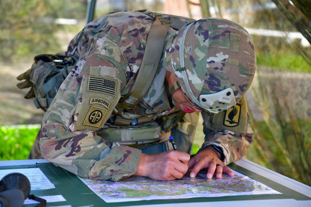 A solider leans over a table and plots a point on a map. (Photo Credit: Paolo Bovo, Training Support Activity Europe)