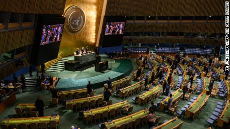 Attendees of a General Assembly meeting stand in silence during a tribute to Britain&#39;s Queen Elizabeth, at the United Nations headquarters in New York on September 15, 2022. (Photo by Ed JONES / AFP) (Photo by ED JONES/AFP via Getty Images)