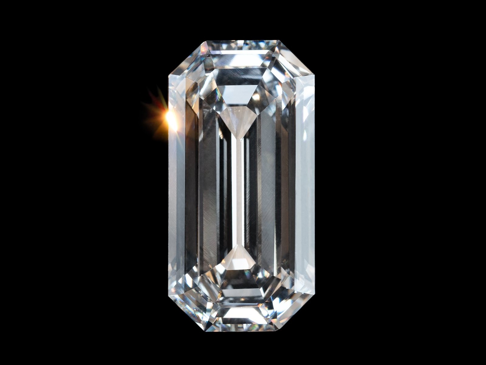 A rectangular shaped colorless gem against a black background