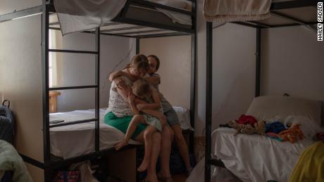 Yulia Morozova embraces her daughters Masha, 14, and Katerina, 3, inside their temporary home at a hotel in Tbilisi, Georgia. She says her children have been clinging to her more since they left their Ukrainian home in April.