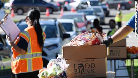 Volunteers load free groceries into cars for people experiencing food insecurity due to the coronavirus pandemic, December 1, 2020 in Los Angeles, California. - As of November 2020, food distribution by the Los Angeles Regional Food Bank has increased by 145% compared to the pre-pandemic levels. (Photo by Robyn Beck / AFP) (Photo by ROBYN BECK/AFP via Getty Images)