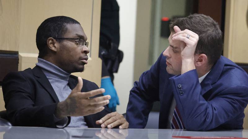 Shooting suspect Michael Boatwright talks to his attorney Joseph Kimok during day six of jury...