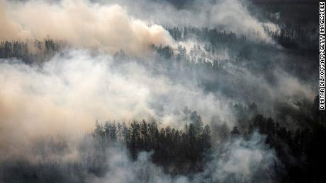 This aerial picture taken from an airplane on July 27, 2021, shows the smoke rising from a forest fire outside the village of Berdigestyakh, in the republic of Sakha, Siberia. - Russia is plagued by widespread forest fires, with the Sakha-Yakutia region in Siberia being the worst affected. According to many scientists, Russia -- especially its Siberian and Arctic regions -- is among the countries most exposed to climate change. The country has set numerous records in recent years and in June 2020 registered 38 degrees Celsius (100.4 degrees Fahrenheit) in the town of Verkhoyansk -- the highest temperature recorded above the Arctic circle since measurements began. (Photo by Dimitar DILKOFF / AFP) (Photo by DIMITAR DILKOFF/AFP via Getty Images)