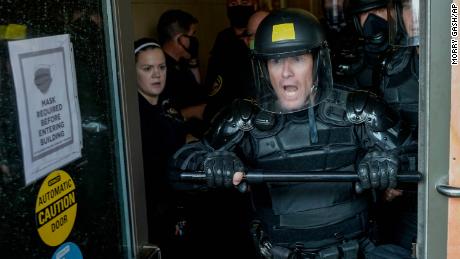 Police try to secure the public safety building from protesters Monday, Aug. 24, 2020, in Kenosha, Wis.Wisconsin Gov. Tony Evers has summoned the National Guard to head off another round of violent protests after the police shooting of a Black man under murky circumstances turned Kenosha into the nation&#39;s latest flashpoint city in a summer of racial unrest.  (AP Photo/Morry Gash)