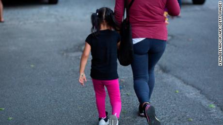 Betty from Ecuador, and her 4 year-old daughter arrive to a food distribution center in Queens on August 25, 2020 in New York City. - As the first day of school approaches, New York&#39;s poorest -- often uninsured families -- face a risky choice: send kids to school where they could contract coronavirus, or keep them home for online classes, potentially compromising their academic progress and preventing parents from working. (Photo by Kena Betancur/AFP/Getty Images)