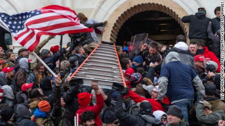  Rioters clash with police using big ladder trying to enter Capitol building through the front doors. Rioters broke windows and breached the Capitol building in an attempt to overthrow the results of the 2020 election. Police used batons and tear gas grenades to eventually disperse the crowd. Rioters used metal bars and tear gas as well against the police. (Photo by Lev Radin/Pacific Press/LightRocket via Getty Images)