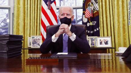 U.S. President Joe Biden signs executive orders in the Oval Office of the White House in Washington, after his inauguration as the 46th President of the United States, U.S., January 20, 2021. REUTERS/Tom Brenner