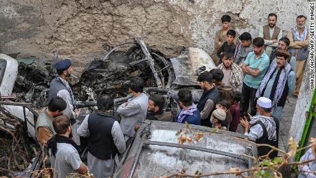 TOPSHOT - Afghan residents and family members of the victims gather next to a damaged vehicle inside a house, day after a US drone airstrike in Kabul on August 30, 2021. (Photo by WAKIL KOHSAR / AFP) (Photo by WAKIL KOHSAR/AFP via Getty Images)