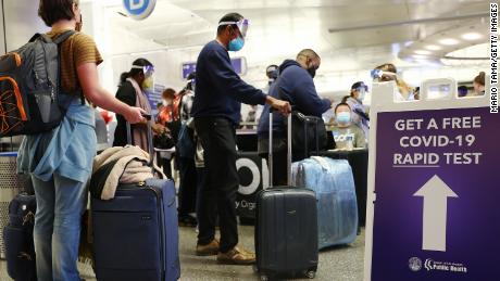 People who arrived on international flights wait to be tested on the first day of a new rapid COVID-19 testing site for arriving international passengers at Los Angeles International Airport (LAX) on December 3, 2021 in Los Angeles, California. The free voluntary tests are being offered to arriving passengers in the Tom Bradley International Terminal by the Los Angeles County Department of Health after the county confirmed its first case of the Omicron variant December 2.