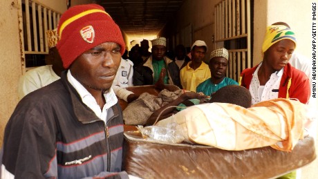 A man injured in a suicide blast is carried by relatives at the General Hospital in northeast Nigerian town of Potiskum on January 12, 2015. Four people were killed and 46 injured when two female suicide bombers detonated their explosives outside a mobile phone market in the town on January 11, 2015. Although no one claimed responsibility the attacks bore the hallmark of Boko Haram Islamists who have been increasingly using female suicide bombers in their armed campaign to establish a hardline Islamic state. Potiskum, the commercial hub of Yobe state has been repeatedly attacked by Boko Haram. AFP PHOTO / Aminu ABUBAKAR (Photo credit should read AMINU ABUBAKAR/AFP/Getty Images)