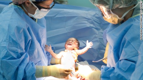  Doctors Susan Farrar (L) and Shannon Lamb (R) deliver a baby girl named Esther by C-section on board the USNS Comfort, a U.S. Naval hospital ship, on January 21, 2010 in Port-au-Prince, Haiti. Esther is the first baby ever born on the ship; her mother suffered a crushed pelvis during Haiti&#39;s recent earthquake. The Comfort deployed from Baltimore with 550 medical personnel on board to treat earthquake victims and arrived in Haiti on January 20. (Photo by Brendan Hoffman/Getty Images)