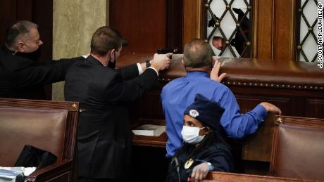 Police with guns drawn watch as protesters try to break into the House Chamber at the U.S. Capitol on Wednesday, Jan. 6, 2021, in Washington. (AP Photo/J. Scott Applewhite)