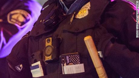 Police keep guard as area residents gather at the site where a Minneapolis Police officers shot and killed a man in Minneapolis, Minnesota, on December 30, 2020. - Police shot the man dead during a traffic stop on December 30, seven months after the killing of George Floyd by an officer in the same US city. No details about the shooting victim, or the officers involved, were immediately available. &quot;Initial witness statements indicate that the subject involved in this felony stop fired first at Minneapolis police officers who then exchanged gunfire with the suspect,&quot; Minneapolis police chief Medaria Arradondo said in a press briefing. (Photo by Kerem Yucel / AFP) (Photo by KEREM YUCEL/AFP via Getty Images)