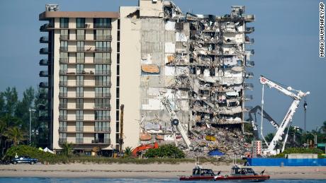 Coast guard boats patrol in front of the partially collapsed Champlain Towers South condo building, ahead of a planned visit to the site by President Joe Biden, on Thursday, July 1, 2021, in Surfside, Fla. Search and rescue workers, who have had to contend with summer rainstorms, fires within the debris, and the threat of collapse from the still standing portion of the building, were not visible atop the rubble on Thursday morning, as scores of people remain missing one week after the collapse.(AP Photo/Mark Humphrey)