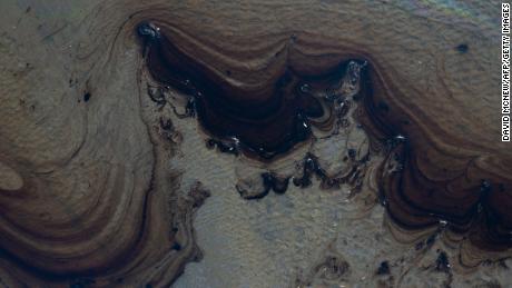 This aerial picture taken on October 3, 2021 shows oil in the water of the Talbert Marshlands area as an oil spill from an offshore oil rig reaches the shore and sensitive wildlife habitats in Newport Beach, California. - Authorities in California&#39;s beachfront Orange County cities scrambled  October 3, 2021 to mitigate the fallout from a major oil spill off the coast that caused &quot;substantial ecological impacts.&quot;  As of Sunday, the oil plume from the 126,000-gallon (480,000 liters) spill of post-production crude was an estimated 5.8 nautical miles (6.7 miles, 10 kilometers) long and stretched along the popular shorelines of Huntington Beach and Newport Beach, Huntington Beach city authorities said in a statement. (Photo by DAVID MCNEW / AFP) (Photo by DAVID MCNEW/AFP via Getty Images)