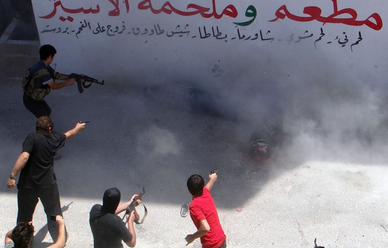 Rebel fighters execute two men on July 25, 2014, in Binnish, Syria. The men were reportedly charged by an Islamic religious court with detonating several car bombs. 