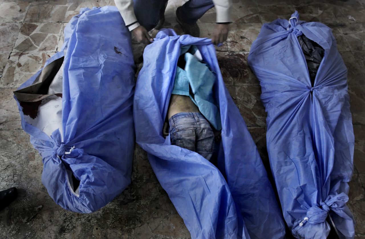 The bodies of three children are laid out for identification by family members at a makeshift hospital in Aleppo on December 2, 2012. The children were allegedly killed in a mortar shell attack that landed close to a bakery in the city.