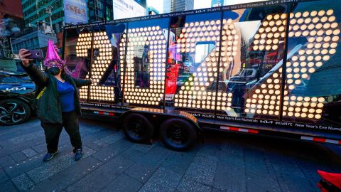 Teresa Hui poses for a selfie in front of a 2022 sign displayed in Times Square, New York, on Dec. 20, 2021.