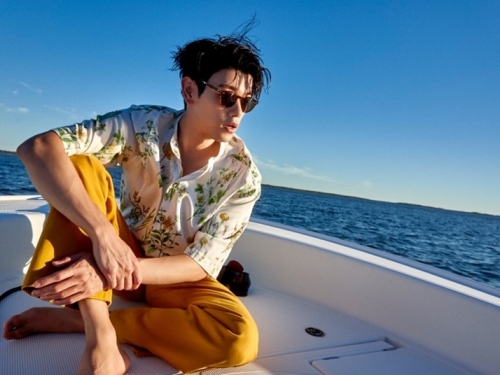 Man sitting on ledge of a boat out at sea