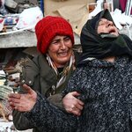 2月，土耳其埃尔比斯坦地区发生大地震后，女人们在一座倒塌的建筑前。