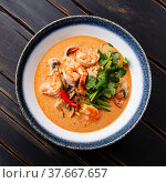 Tom Yam kung Spicy Thai soup with shrimp, seafood, coconut milk and chili pepper in bowl close-up. Стоковое фото, фотограф Лисовская Наталья / Фотобанк Лори