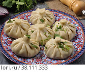 khinkali with meat on a clay plate decorated with greenery. Стоковое фото, фотограф Дмитрий Ульянов / Фотобанк Лори