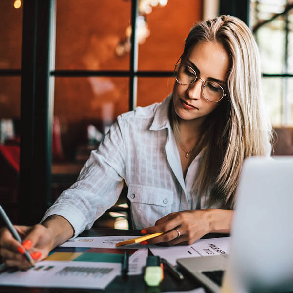 female in glasses writing