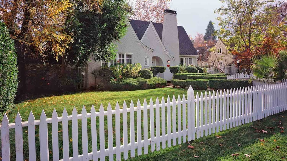 large house with white picket fence in the fall