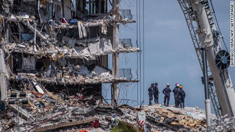 TOPSHOT - Members of the South Florida Urban Search and Rescue team look for possible survivors in the partially collapsed 12-story Champlain Towers South condo building on June 27, 2021 in Surfside, Florida. - The death toll after the collapse of a Florida apartment tower has risen to nine, the local mayor said on June 27, 2021, more than three days after the building pancaked as residents slept. &quot;We were able to recover four additional bodies in the rubble... So I am confirming today that the death toll is at nine,&quot; Miami-Dade County mayor Daniella Levine Cava told reporters in Surfside, near Miami Beach, adding that one victim had died in hospital. &quot;We&#39;ve identified four of the victims and notified next of kin.&quot; (Photo by Giorgio Viera / AFP) (Photo by GIORGIO VIERA/AFP via Getty Images)