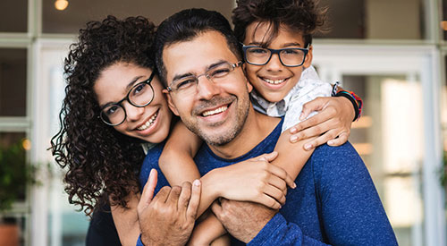 a father with his two daughter smiling for camera