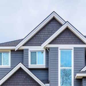 The top of a grey house with nice windows