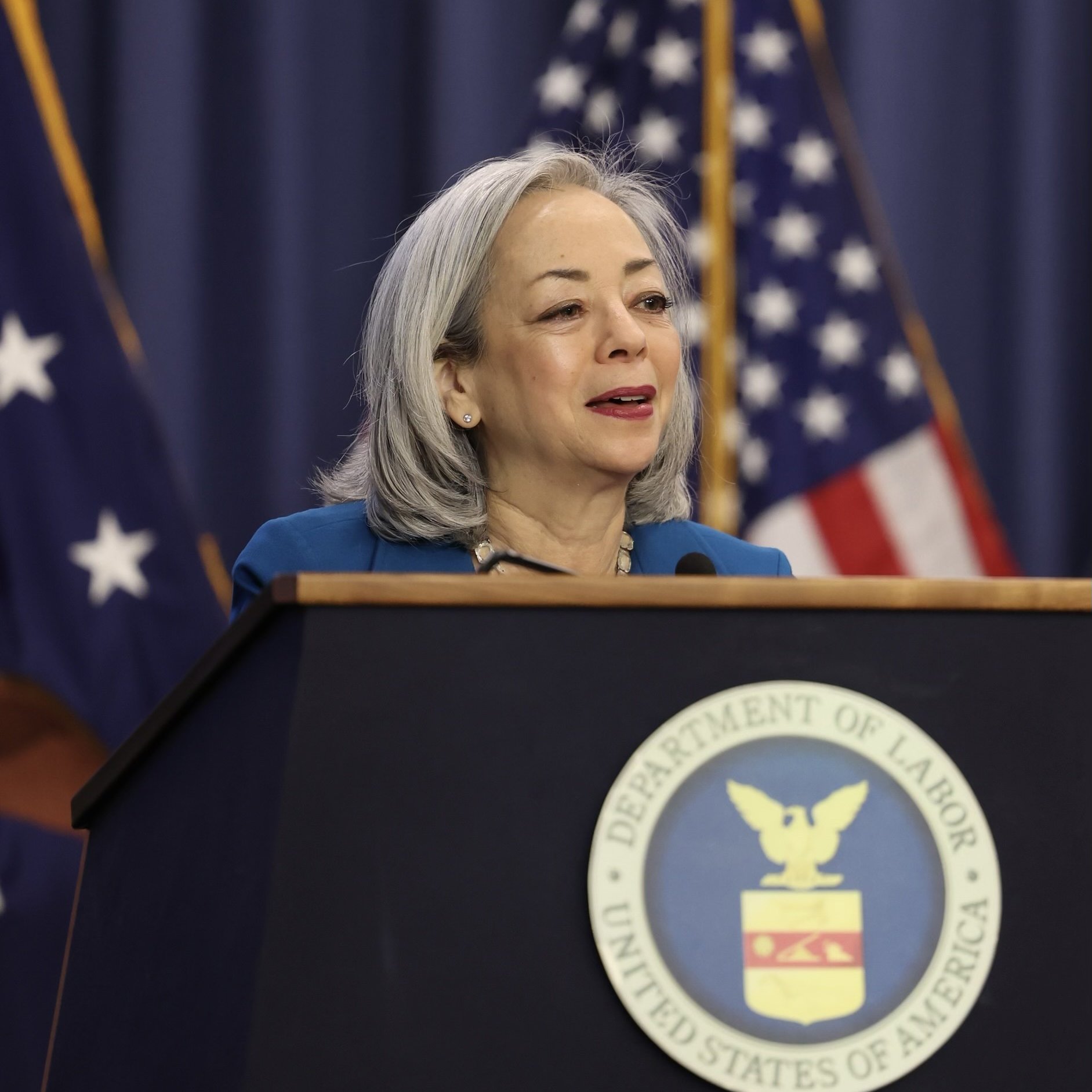 Deputy Undersecretary for International Labor Affairs Thea Lee speaks at a podium with the Department of Labor seal.